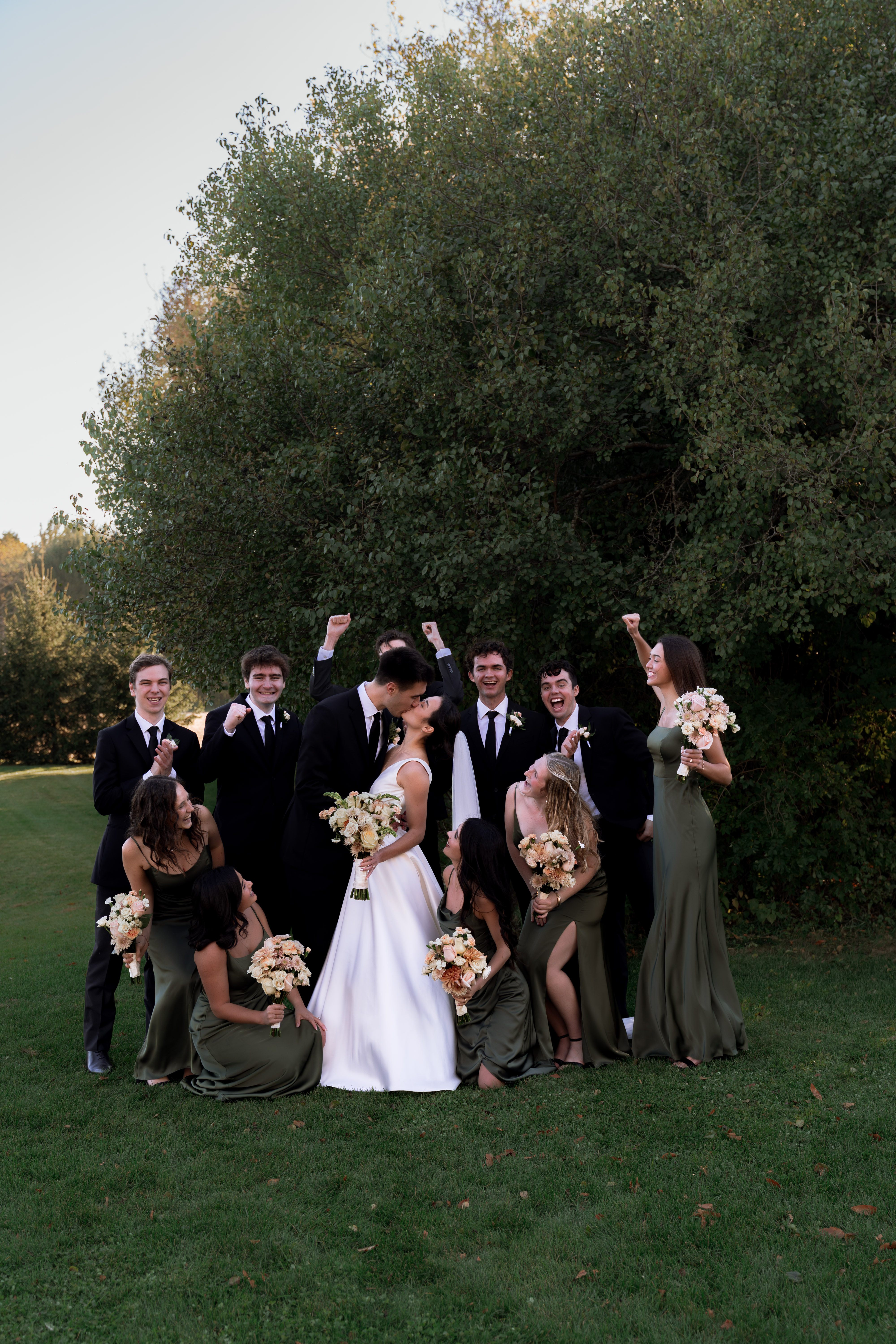 Wedding party celebrating with bride and groom on lawn